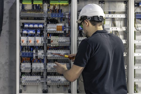 A male electrician works in a switchboard using an electrical connection cable, connecting equipment with tools. View from the back. SSUCv3H4sIAAAAAAAACpySz27DIAzG75P2DhHnRmqgIdlepdrBAbdBpVAB6TRVfffxJ6nYdbf4Z/uzP5zH+1vTkAm8EuSzeaQoxkrrxQcHQVkT8X63codGoqvJ3TG+rwGoOkKpgnUKdA0nCGI2cMUIzaJ1ws+cJD5AWDz6tMuKBAQ8R40CXxJl4WOJmy2Rk7EjpgjZVcwvU2YbKuL/6iwfXy/DZzTiJy9cGXGoEYqRYykll++A7lpbg0UqW7m6WwE6FbBKCdQNHPzpuzkllDlXxIY532VTEnYxwaWtXmaItvYGk06vfopjcOMzeB/L5car2SL+BfZazTE2ZE+rKpHxOCnsGOsPI2V0P3A+MEqHtaAcdFZRJ6+zCcVYXJSsXam0AenGXg4dyvY0Am8PnMt2xJ61lLMT/aB9d5AYb/H8BQAA//8DAI/GePq5AgAA